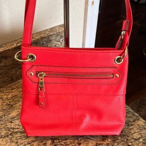 Woman’s coral colored shoulder bag.